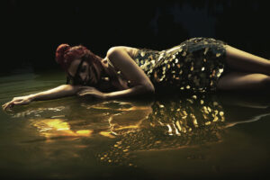 Colostrum: The Latest in Anti-Aging -- Attractive lady lying in liquid chocolate