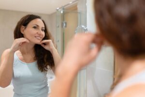 Lower facelift feature; woman looking at her neck or jawline