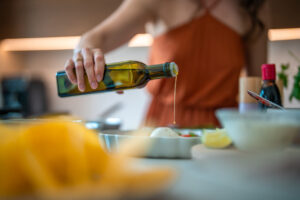 Woman cooking with olive oil; olive oil and dementia prevention