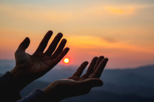 Woman worship on sunset. Why So Many Americans Still Believe in God