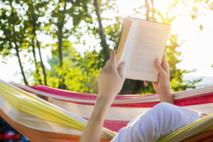 reading at dusk in the hammock with the open book. Books to Kick Off the Summer