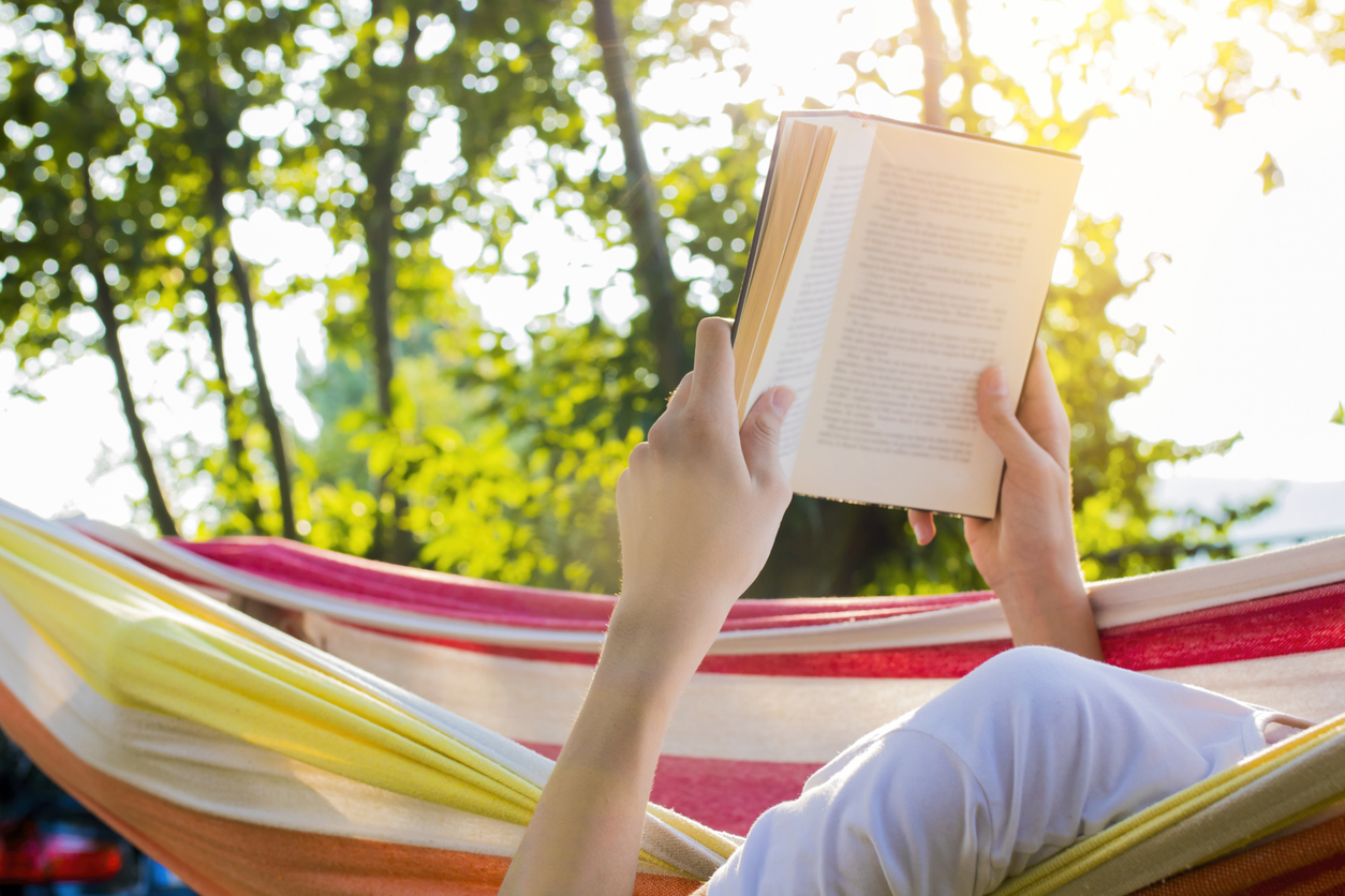 reading at dusk in the hammock with the open book. Books to Kick Off the Summer