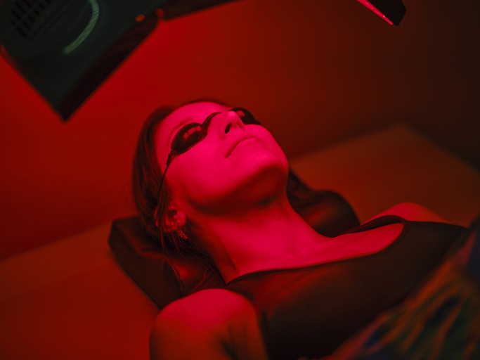 Woman On an LED Bed Receiving Red Light Therapy. How Red Light Therapy Works for Pain Management