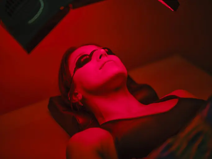 Woman On an LED Bed Receiving Red Light Therapy. How Red Light Therapy Works for Pain Management