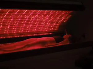 Woman On an LED Bed Receiving Red Light Therapy. Red Light Therapy for Pain Management