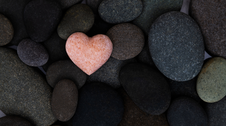 Pink stone heart in a stone heap. What Scripture Says About God's Love