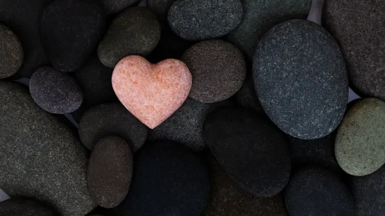 Pink stone heart in a stone heap. What Scripture Says About God's Love