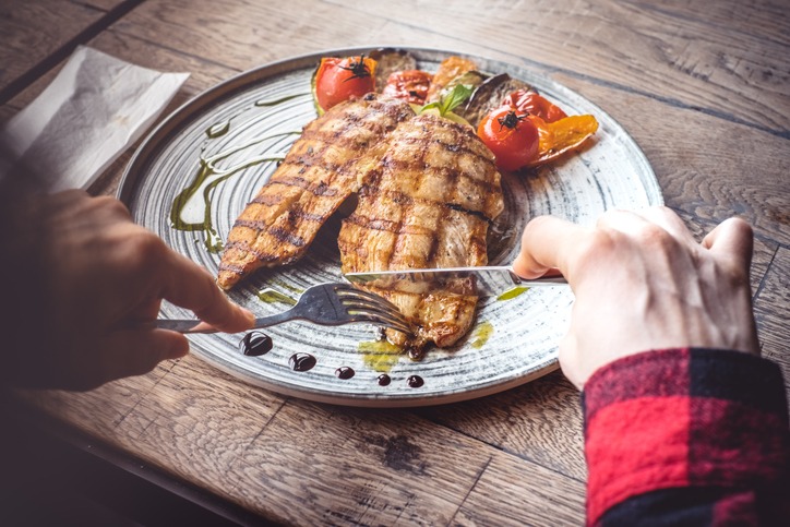 Eating grilled chicken. Women Over 50 Need More Protein